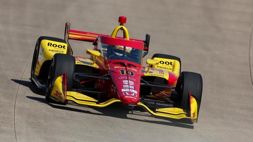 Red racing car with driver on a track, showcasing speed and sport dynamics.